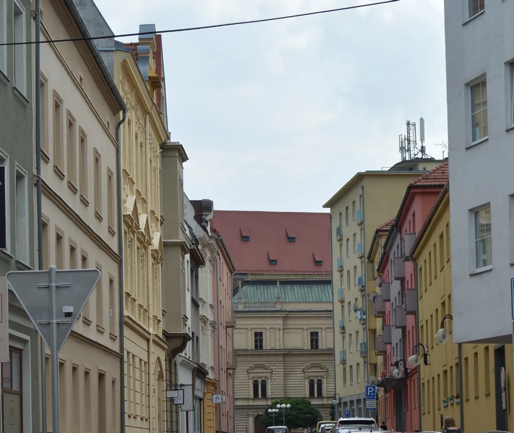 Pohled do opavské ulice s historickými fasádami, v pozadí věž a měšťanské domy.